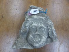 RETRIEVED FROM KENCOT, A 14th C. CARVED LIMESTONE HEAD WITH HAIR CURLED DOWN TO THE CHEEKS AND BELOW