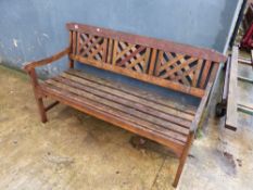 A PAIR OF TEAK GARDEN BENCHES WITH LATTICE PANEL BACKS. (2)