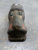 A CARVED WOOD DOG HELMET MASK, POSSIBLY MAMBILA, THE BLUE BEAD EYES ABOVE A TONGUE LOOSE WITHIN