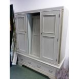 A MODERN PAINTED PINE TRIPLE DOOR WARDROBE WITH A TWO DRAWER BASE AND SHAPED BRACKET FEET. 166 x