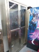 A LARGE STAINLESS STEEL GLAZED CABINET.