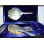 A SILVER HALLMARKED THREE PART DRESSING SET IN CASE AND A WHITE METAL SMALL ASHTRAY.