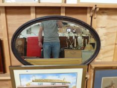 A LARGE OAK FRAMED WALL MIRROR.