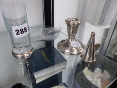 A SILVER MOUNTED SHOT GLASS, A CANDLESTICK, SILVER SNUFFER AND TWO CADDY SPOONS.