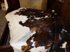 A LARGE COW HIDE RUG.