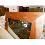 A LARGE MAPLE WOOD FRAMED MIRROR.