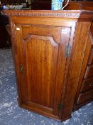 A GEORGIAN OAK CORNER CABINET.