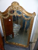 A GILT FRAMED MIRROR.