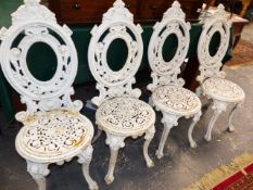 A SET OF FOUR CAST IRON GARDEN CHAIRS.