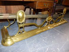 AN ART NOUVEAU BRASS FIRE FENDER AND VARIOUS BRASS CURTAIN RAILS.