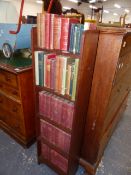 A SMALL OAK BOOKCASE WITH BOOKS.