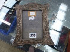 AN ANTIQUE SILVER FRONTED PHOTO FRAME.