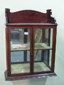 AN EDWARDIAN MAHOGANY WALL CABINET. THE SHELF TOP OVER SATIN WOOD BANDED GLAZED DOORS ENCLOSING