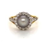 A CULTURED PEARL AND DIAMOND YELLOW METAL RING. THE GREY 8.5mm CULTURED PEARL SITS IN THE CENTRE