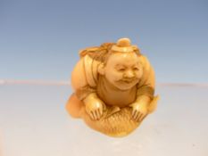 AN IVORY OKIMONO OF EBISU KNEELING WITH HIS HANDS ON A FISH, LACQUER SIGNATURE, SEICHI?. H 3cms