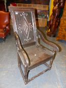 AN OAK WAINSCOT ARMCHAIR, CHEVRON BANDS ENCLOSING THE DIAMOND CARVED BACK PANEL, THE SEAT WITH