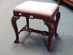 A WALNUT STOOL IN THE GEORGIAN TASTE THE DROP IN SEAT ON CABRIOLE LEGS CARVED WITH FOLIAGE AT THE