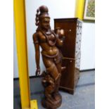 AN INDIAN CARVED HARDWOOD NEAR LIFE SIZE FIGURE OF A LADY CARRYING A WATER JAR, TWO GARLANDS