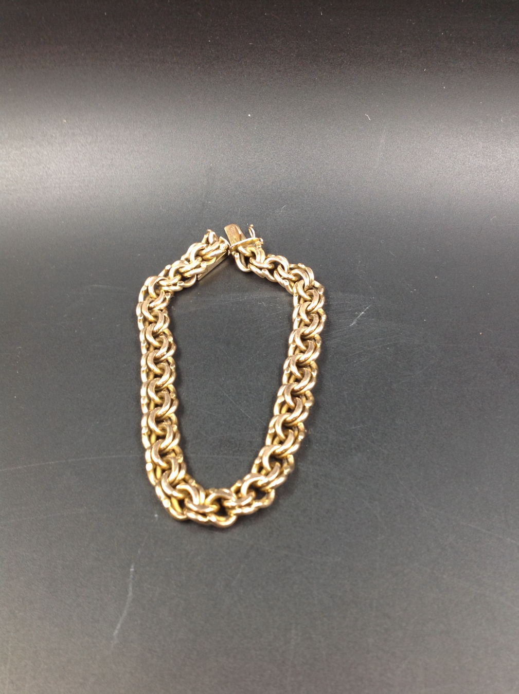 A 14CT GOLD DOUBLE INTERWOVEN SOLID CURB BRACELET, LENGTH 22cms, WEIGHT 47grms.