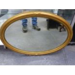 AN EDWARDIAN GILT OVAL WALL MIRROR IN REEDED FRAME. 62 x 86cms.