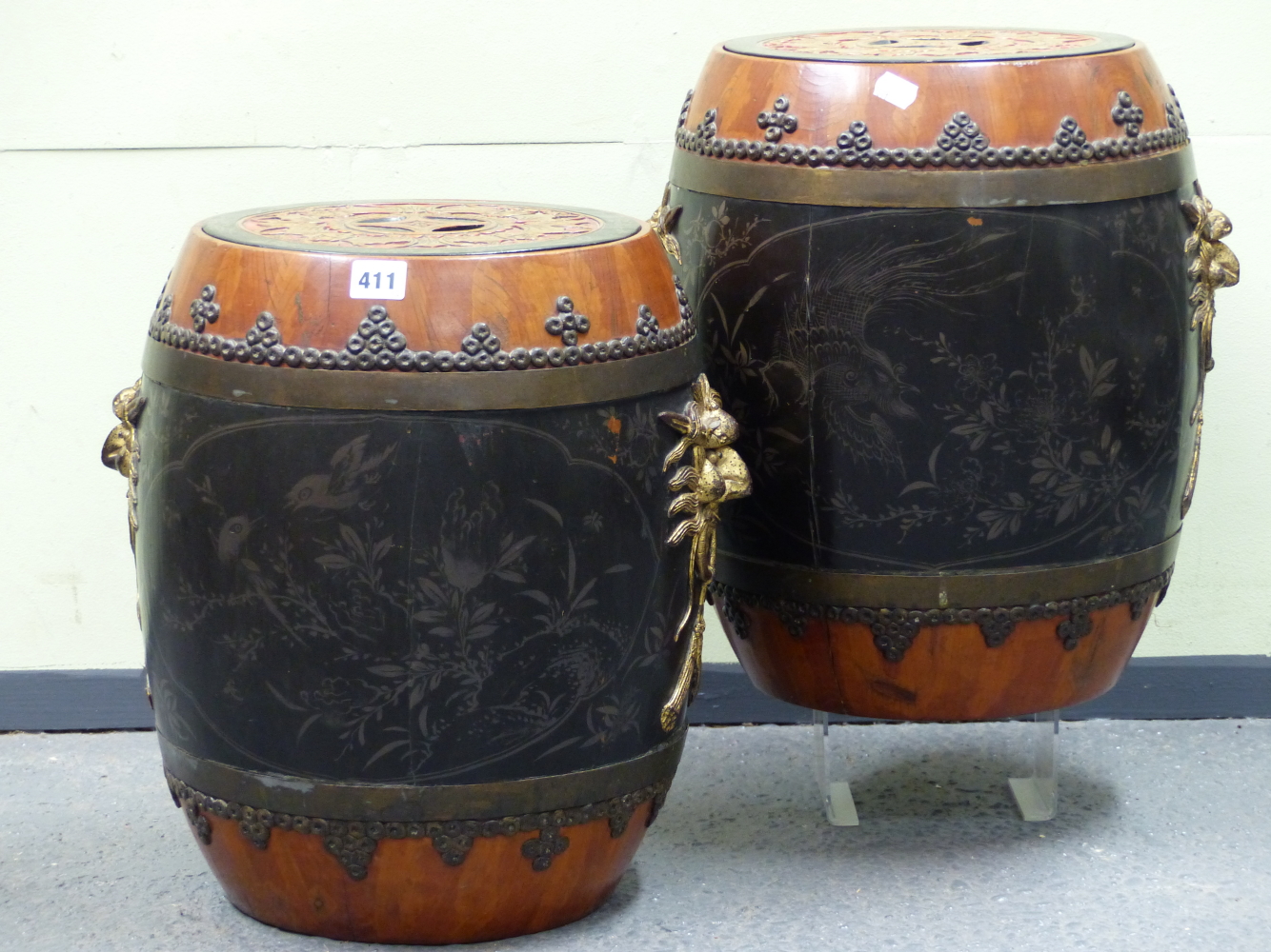 A PAIR OF BLACK LACQUERED WOOD BARREL SHAPED JARS, THE RED GROUND COVERS WITH CASH MEDALLION INSET