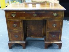 A GEORGIAN STYLE WALNUT KNEEHOLE DESK, THE APRON DRAWER OVER A CUPBOARD IN THE KNEEHOLE FLANKED BY