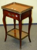 A BRASS GALLERIED MAHOGANY TWO TIER TABLE, THE TOP TIER WITH SINGLE APRON DRAWER, THE CABRIOLE