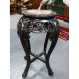 A CHINESE HARD WOOD STAND INLAID WITH MARBLE ROUNDEL ABOVE A PIERCED FLORAL APRON AND CABRIOLE