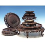 A COLLECTION OF EIGHT CHINESE HARDWOOD VASE STANDS, A PLATE STAND, A DUCK HANDLED WOODEN BOWL AND