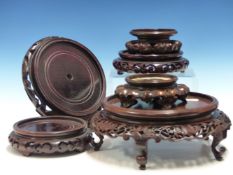 A COLLECTION OF EIGHT CHINESE HARDWOOD VASE STANDS, A PLATE STAND, A DUCK HANDLED WOODEN BOWL AND