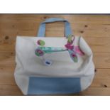 A RADLEY CREAM CANVAS CARRIER BAG WITH PALE BLUE LEATHER HANDLE AND FLORAL LINED INTERIOR.