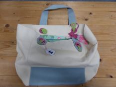 A RADLEY CREAM CANVAS CARRIER BAG WITH PALE BLUE LEATHER HANDLE AND FLORAL LINED INTERIOR.