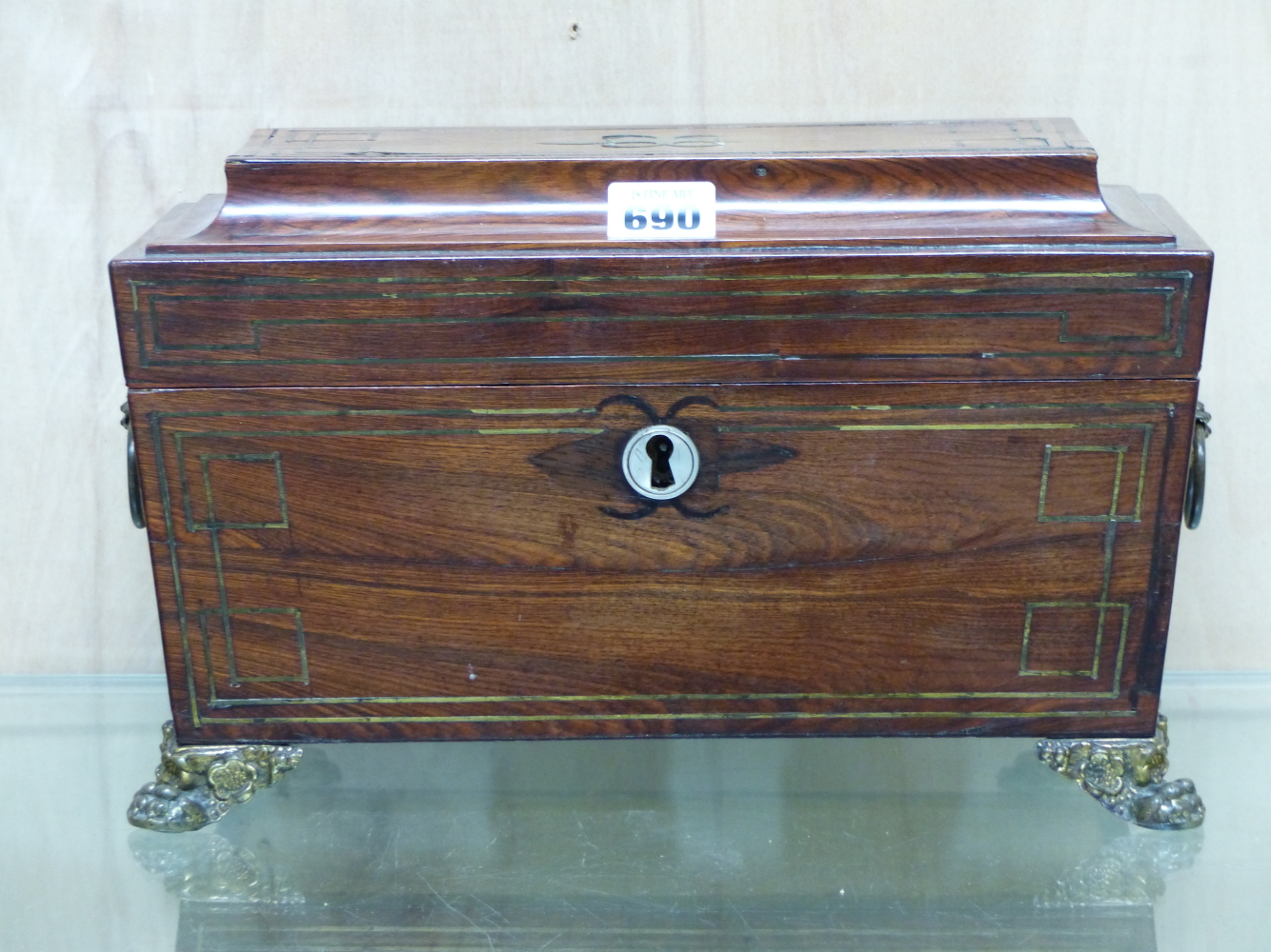 A REGENCY ROSEWOOD AND BRASS INLAID SARCOPHAGUS FORM TEA CADDY WITH BRASS RING HANDLES AND FEET. W.