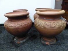 A PAIR OF HATHERN STATION CO. LTD. RED TERRACOTTA PLANTERS, THE ROUND RIMS ABOVE FLOWER HEAD BANDS