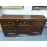 A GEORGIAN PINE DRESSER THE THREE DRAWERS WITH BRASS HANDLES ABOVE TWO CUPBOARDS FLANKING A