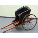 A 19th C. CHILD'S DOG CART, THE BUTTON UPHOLSTERED SEAT ABOVE A RED FOOT WELL, THE IRON SPOKED