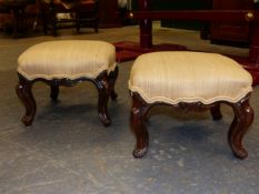 A PAIR OF MAHOGANY FOOTSTOOLS, BEIGE UPHOLSTERED ABOVE FOLIATE CARVED CABRIOLE LEGS.