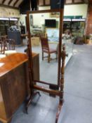 A REGENCY MAHOGANY CHEVAL MIRROR, THE RECTANGULAR PLATE WITHIN AN EBONY LINE EDGED FRAME, THE