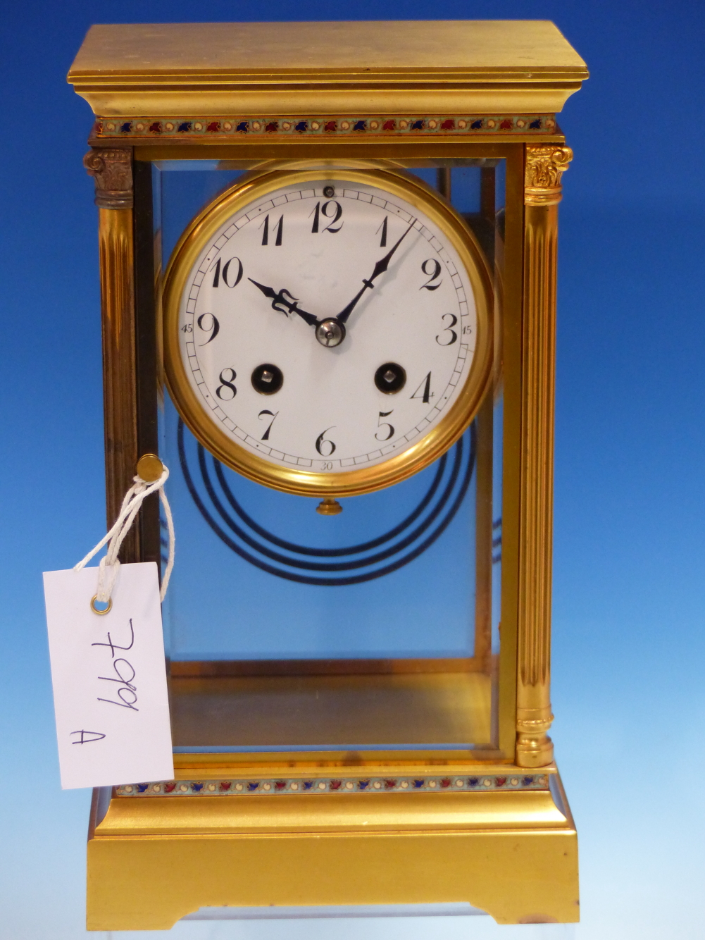 A FRENCH GILT METAL MOUNTED BEVELLED GLASS CASED MANTEL CLOCK STRIKING ON A COILED ROD, THE