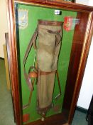 A VINTAGE GOLFING DISPLAY OF EARLY 20th.C.BAG & CLUBS, CRESTED CLUB SHIELD AND A TROPHY IN A