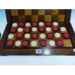 A RED AND WHITE IVORY CHESS SET, THE KINGS. H. 9cms THIRTY IVORY DRAUGHTS ROUNDELS STAINED RED AND
