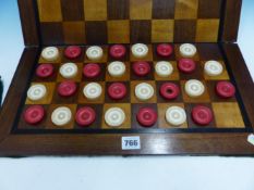 A RED AND WHITE IVORY CHESS SET, THE KINGS. H. 9cms THIRTY IVORY DRAUGHTS ROUNDELS STAINED RED AND