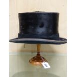 A HERBERT JOHNSON BRUSHED SILK TOP HAT WITH TURNED TREEN WIG STAND. H 25cms