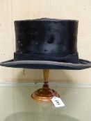 A HERBERT JOHNSON BRUSHED SILK TOP HAT WITH TURNED TREEN WIG STAND. H 25cms