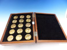 A MAHOGANY CASED SET OF FIFTEEN GILT MEDALLIONS DEPICTING THE BRITISH MONARCHS FROM WILLIAM II TO