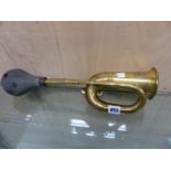 A DELUXE BUGLE SHAPED BRASS CAR HORN BLOWN BY A BLACK BULB OF RUBBER. W 45cms