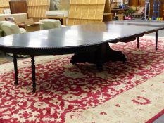 AN IMPRESSIVE 19th.C.EBONISED EXTENDING DINING TABLE ON CARVED CENTRE POD SUPPORT WITH RAIL