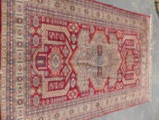 AN ORIENTAL RUG OF CAUCASIAN DESIGN 277 x 182cms.