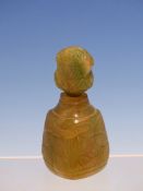 AN INDIAN GREENSTONE SCENT BOTTLE AND STOPPER, THE SIDES OF TRIANGULAR SECTION CARVED IN RELIEF WITH