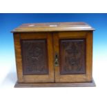 AN OAK WALL MOUNTING SMOKERS CABINET PRESENTED IN 1911 TO F SCHOLES, THE INTERIOR OF THE DOORS